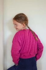 Fille portant un Pull ANGEL rose, avec manches chauve-souris, patron de couture pdf à télécharger. Modèle décontracté.