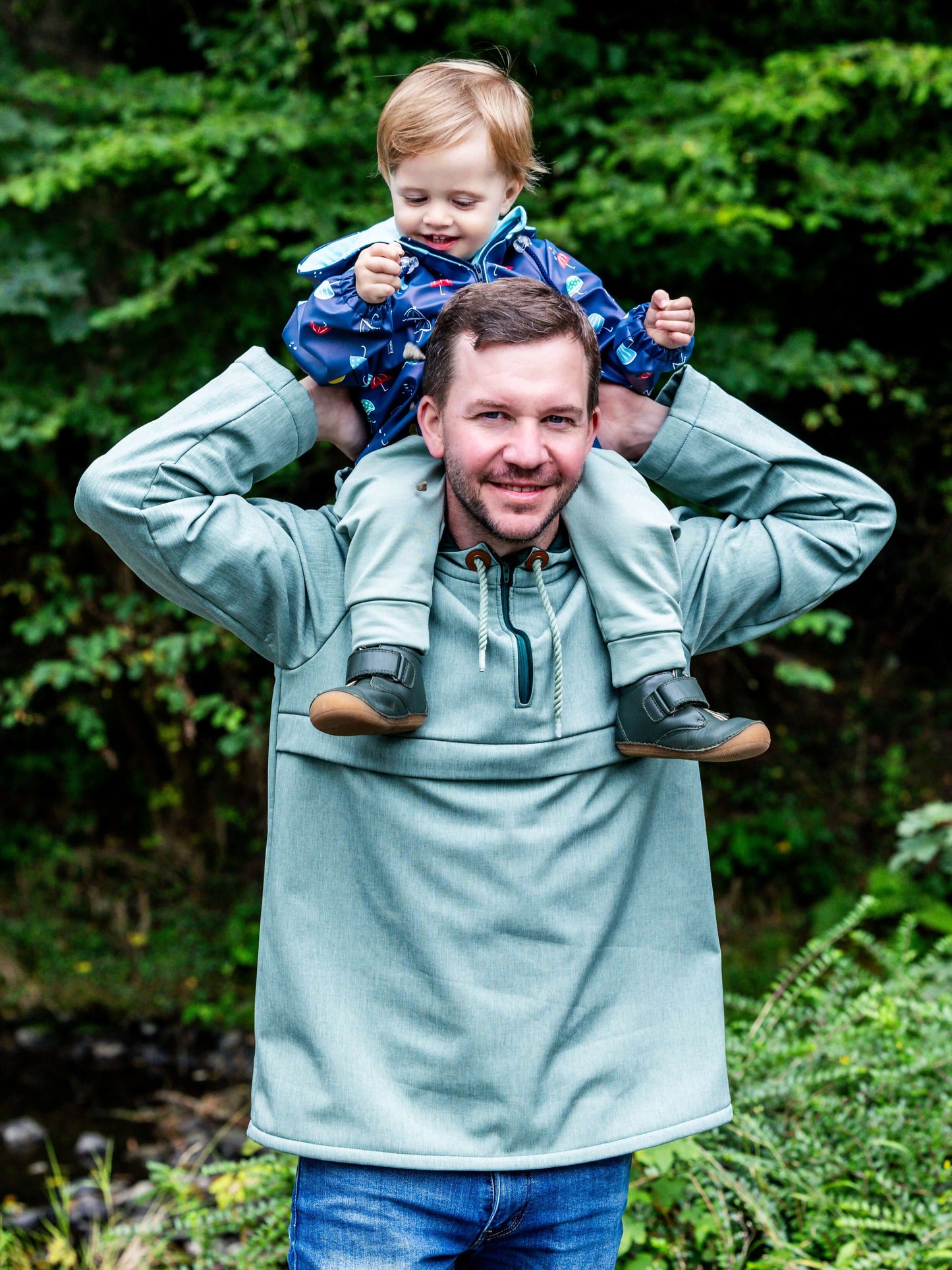 Homme portant enfant avec QUETSCHE - Le coupe-vent à poche ventrale, patron de couture pdf à télécharger, idéal pour toute la famille.