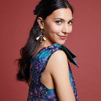 Femme portant une Robe L'Audacieuse - T34 à 48, patron de couture pdf à télécharger, avec un design floral et des détails élégants.