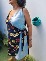 Femme portant une robe courte portefeuille à fleurs, style féminin, parfaite pour les couturières débutantes.