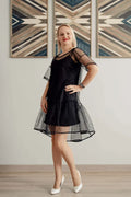 Femme portant la Robe Sparkle - Patron couture PDF du XS au L, élégante et sophistiquée, dans un cadre moderne et chic.