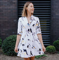 Robe XS-XL - SOULMATE, patron de couture PDF à télécharger, femme portant une robe imprimée florale devant un mur de briques.