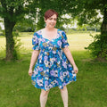 Femme portant une Robe ou Blouse Hirondelle | Taille 32 à 50, modèle fleuri, patron de couture pdf à télécharger.