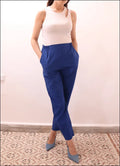 Modèle portant le SURI PANTALON-taille de 30 à 58 EU, pantalon bleu à pli, ceinture élastiquée, avec patron de couture pdf à télécharger.