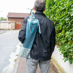 Homme portant le Sac à baguettes de pain Miss Cactus - Patron couture PDF, pratique et écologique, avec fermeture par rubans.