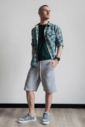Short homme XS - XXL - WEEKEND, patron de couture PDF à télécharger, modèle présenté par un homme portant un short gris et chemise à carreaux.