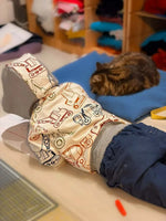 Enfant portant le Sweat AVENTURIER - Patron de couture PDF Enfant du 2 au 16 ans, allongé près d'un chat, sur un lit.