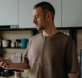 Homme portant un T-shirt homme du XXS au XXL - DOMINO dans une cuisine, patron de couture pdf à télécharger pour t-shirt homme.