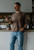 Homme portant un T-shirt homme du XXS au XXL - DOMINO, patron de couture pdf à télécharger, dans une cuisine moderne.