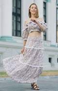 Femme portant Top et jupe longue style bohème - XS/XL - EL PASION, patron de couture pdf à télécharger, extérieur devant un bâtiment.