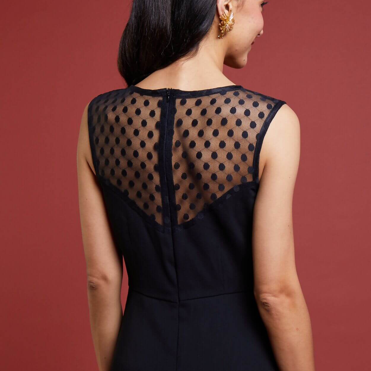 Robe noire festive La Coquette avec dos en dentelle transparente à pois, idéale pour les soirées élégantes.