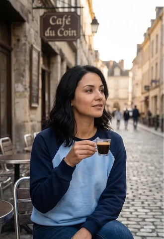 Femme savourant un café en terrasse portant le Sweat Livarot Adulte Taille 34 à 54, patron de couture PDF à télécharger, devant Café du Coin.