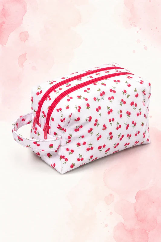 Trousse ZeepZeep en tissu blanc à motif cerises avec deux fermetures éclair rouges, patron PDF gratuit.
