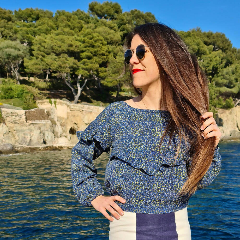 Blouse Embrun en tissu floral, idéale pour customisation et couture, portée près de l'eau avec des lunettes de soleil.