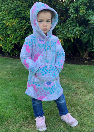 Enfant portant une robe sweat à motifs colorés avec capuche sur une pelouse. Duo Mère-Fille de robe sweat MILA (2-16 Ans / 34-54).