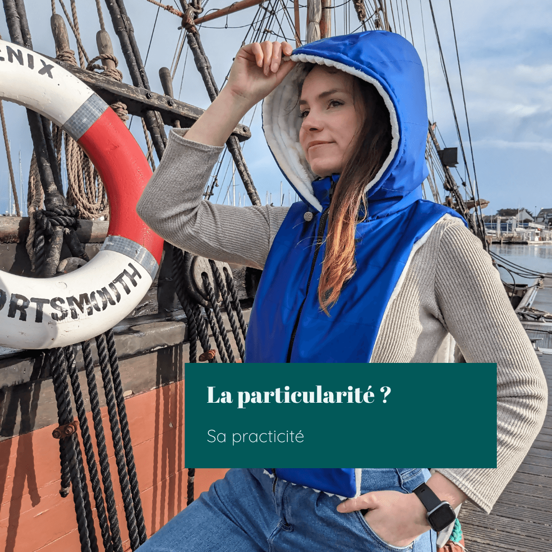 Femme portant une capuche Beira bleue sur un bateau, mettant en avant sa praticité et style.