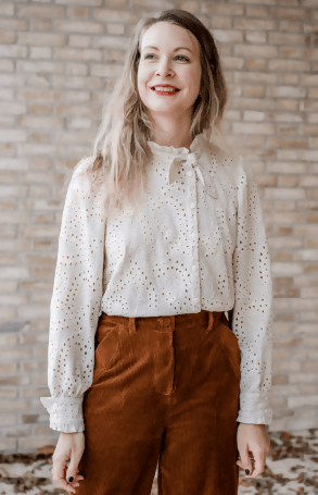 Blouse ENOÉ élégante avec col noué et volanté, portée avec un pantalon en velours, modèle à coudre.