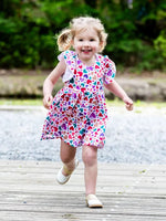 Petite fille souriante portant la robe colorée AIRELLE - La robe / blouse aux 1000 versions, patron de couture PDF à télécharger.