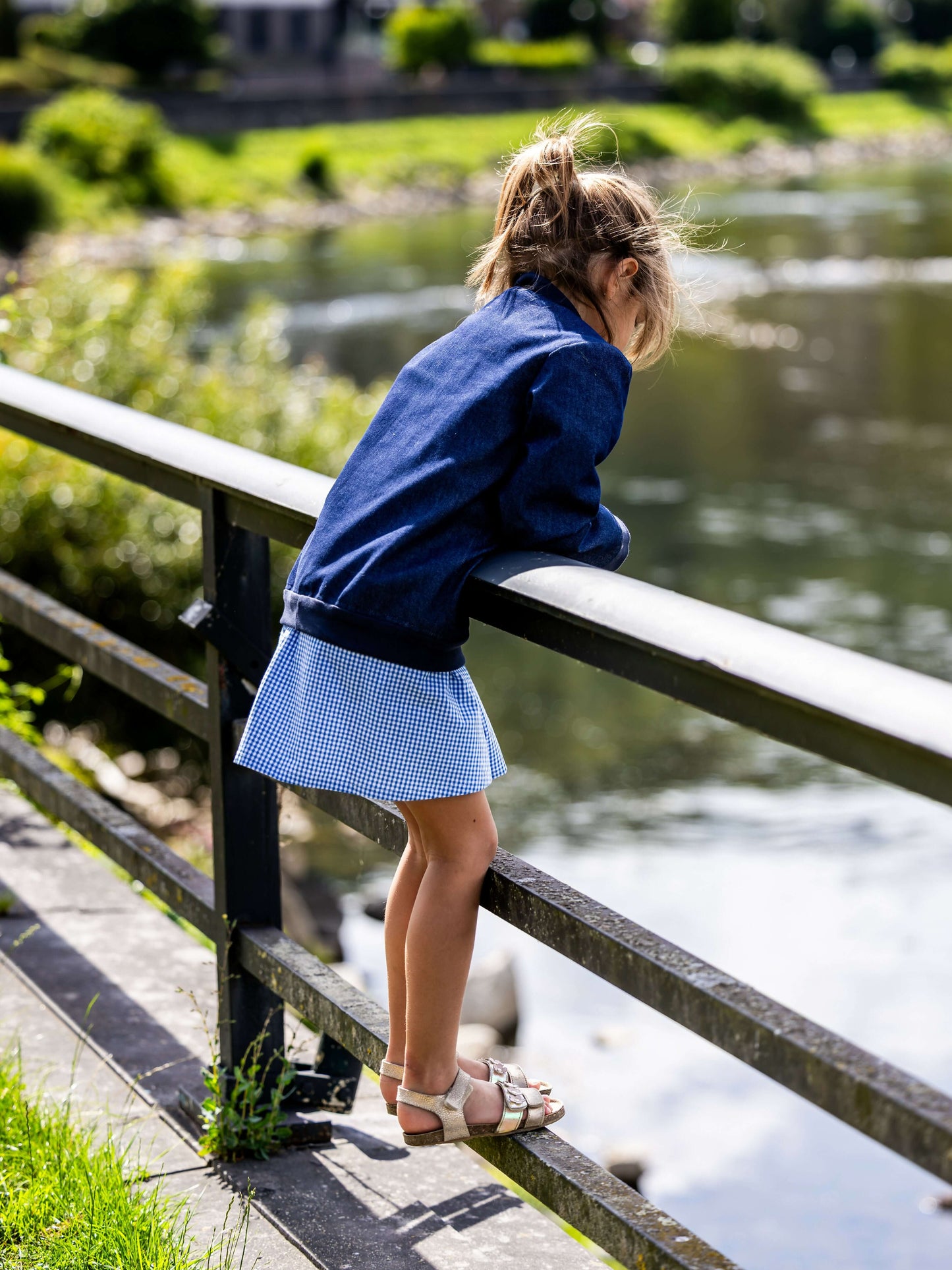 Enfant portant AMANDE : le bomber, patron de couture PDF à télécharger, en bord côte, au bord d'une rivière, journée ensoleillée.