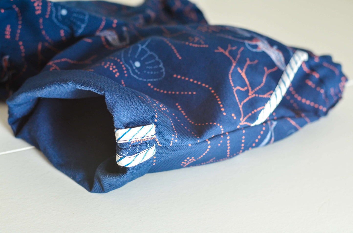 Détail d'un bermuda BASALTE en tissu imprimé marine, montrant les poches et coutures soignées.