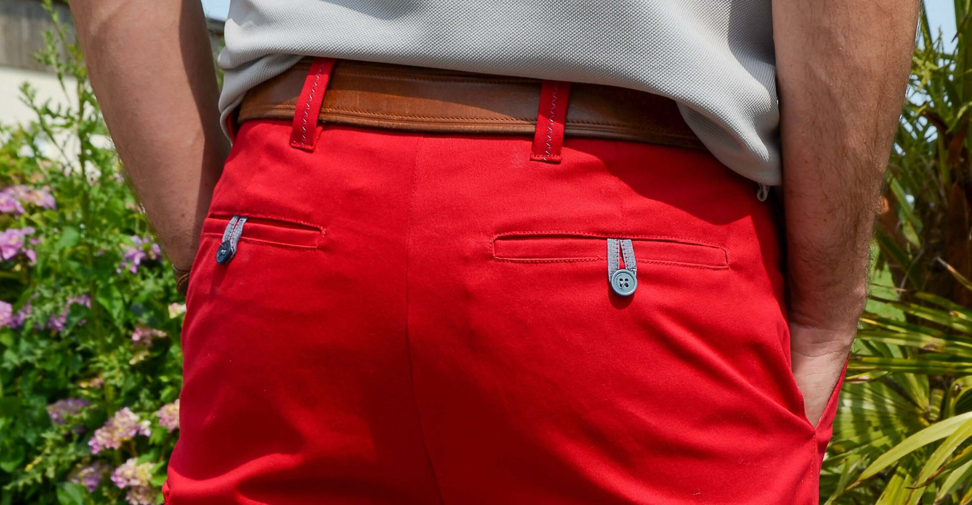Vue arrière d'un bermuda tendance rouge avec poches passepoilées et ceinture en cuir.