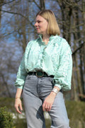 Femme portant la Blouse Anoushka verte, patron de couture pdf à télécharger, avec col montant et manches longues froncées.