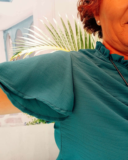 Détails de la blouse Némésis avec col froncé et manches courtes volantées, parfaite pour l'été.