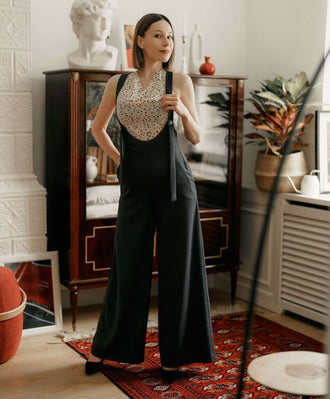 Modèle féminin portant une blouse à pois et une combinaison noir, décor intérieur élégant.