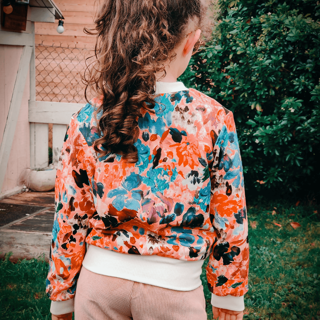 Enfant portant le Bombers Ibis kids | Taille 2 à 12 ans avec motif floral, patron de couture pdf à télécharger, vue de dos.