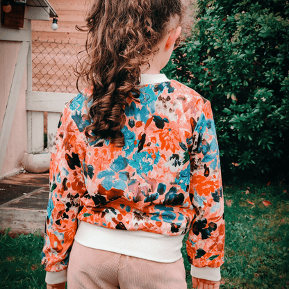 Enfant portant le Bombers Ibis kids | Taille 2 à 12 ans avec motif floral, patron de couture pdf à télécharger, vue de dos.