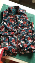 Patron PDF Bomber Phoenix, vue détail de la veste matelassée à fleurs rouges et roses sur fond marine, fermée par zip