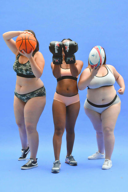 Trois femmes sportives avec des ballons en brassière de sport, illustrant le confort et le style pour des activités modérées.