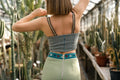 Femme portant un Bustier - XS/L - NUMBER ONE dans une serre, photo de dos avec des cactus environnants.