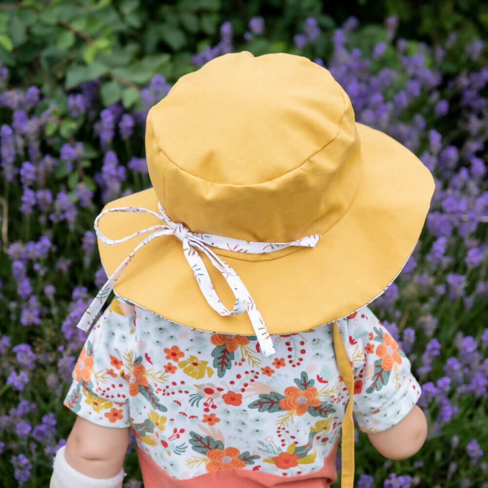 Enfant portant CARAMBOLE - le bob réversible jaune, patron de couture pdf à télécharger, idéal pour protéger du soleil.