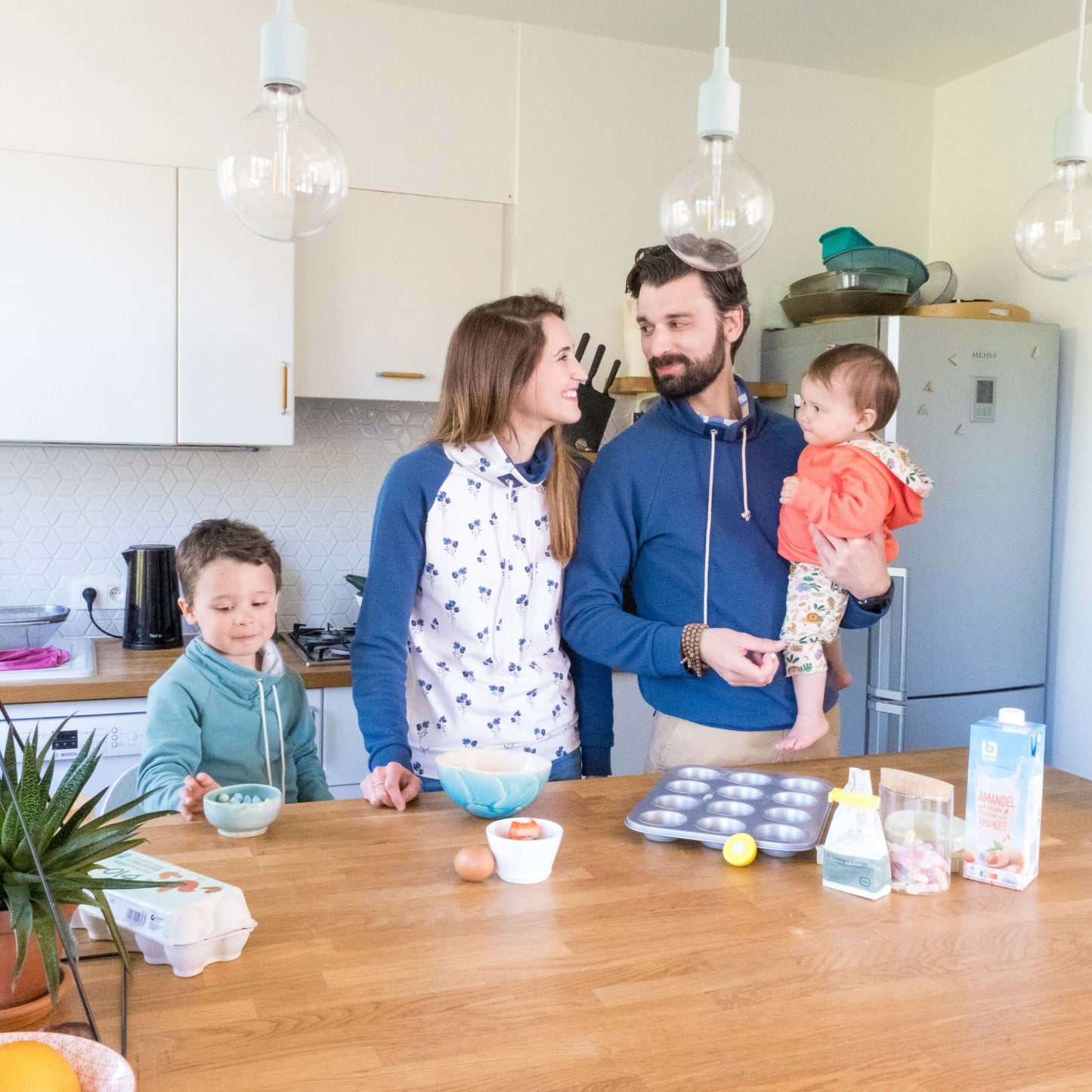 Famille portant des sweats "CHATAIGNE - LE sweat aux 32 versions" préparant un repas ensemble dans la cuisine, patron de couture pdf à télécharger.