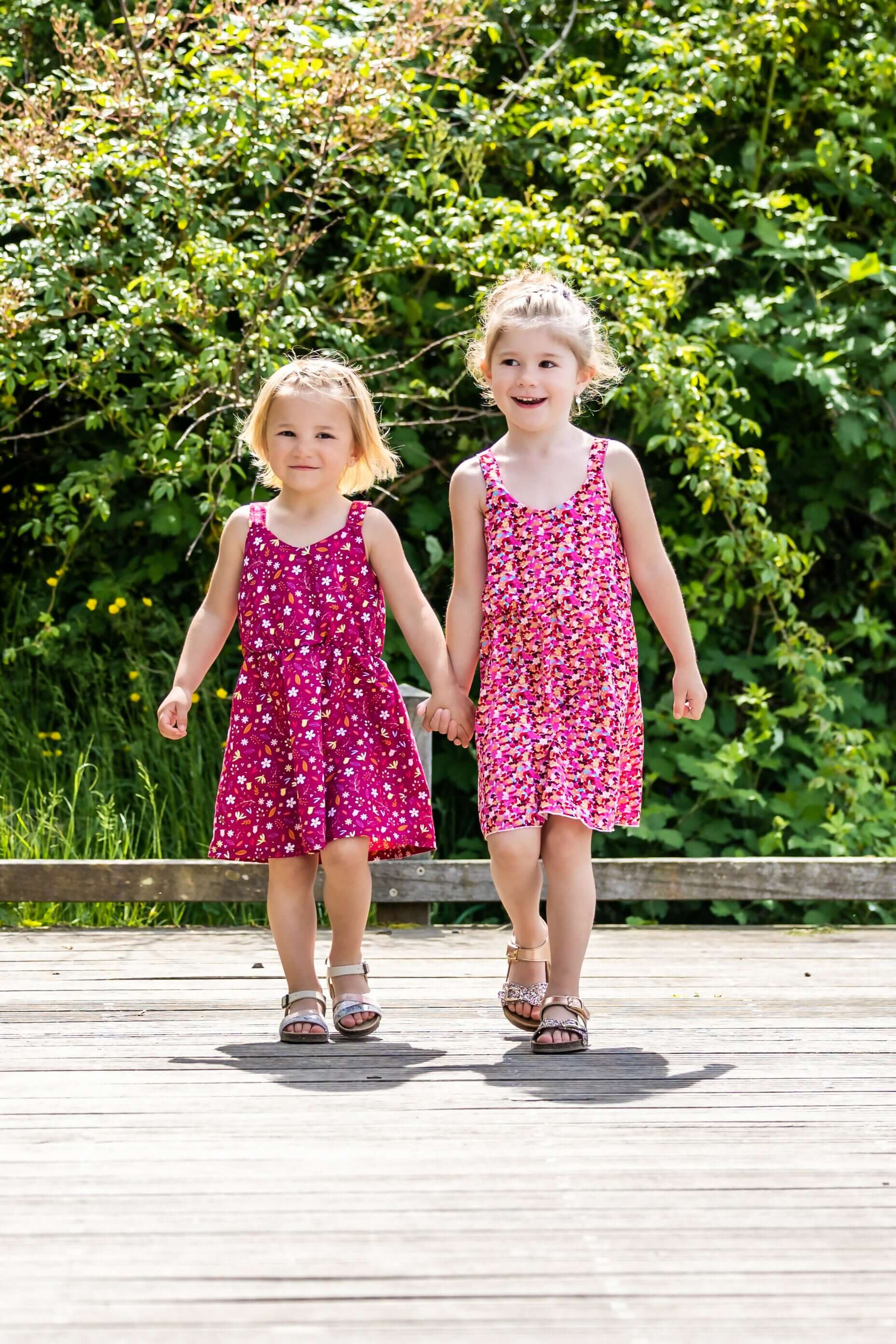 Deux filles portant CLEMENTINE - Le top et la robe d'été, patron de couture pdf à télécharger, marchant main dans la main.