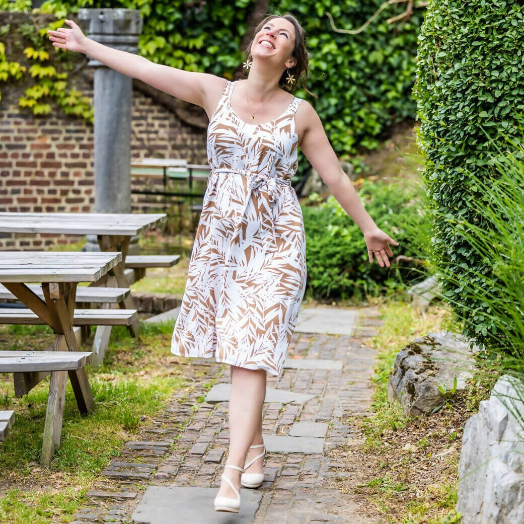 Femme portant CLEMENTINE - Le top et la robe d'été dans un jardin, patron de couture pdf à télécharger.