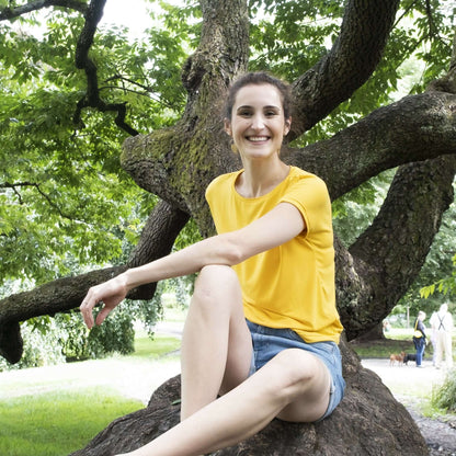 Femme souriante portant le t-shirt CRANBERRY - Le t-shirt pour toute la famille, patron de couture pdf à télécharger, assise dans un parc.