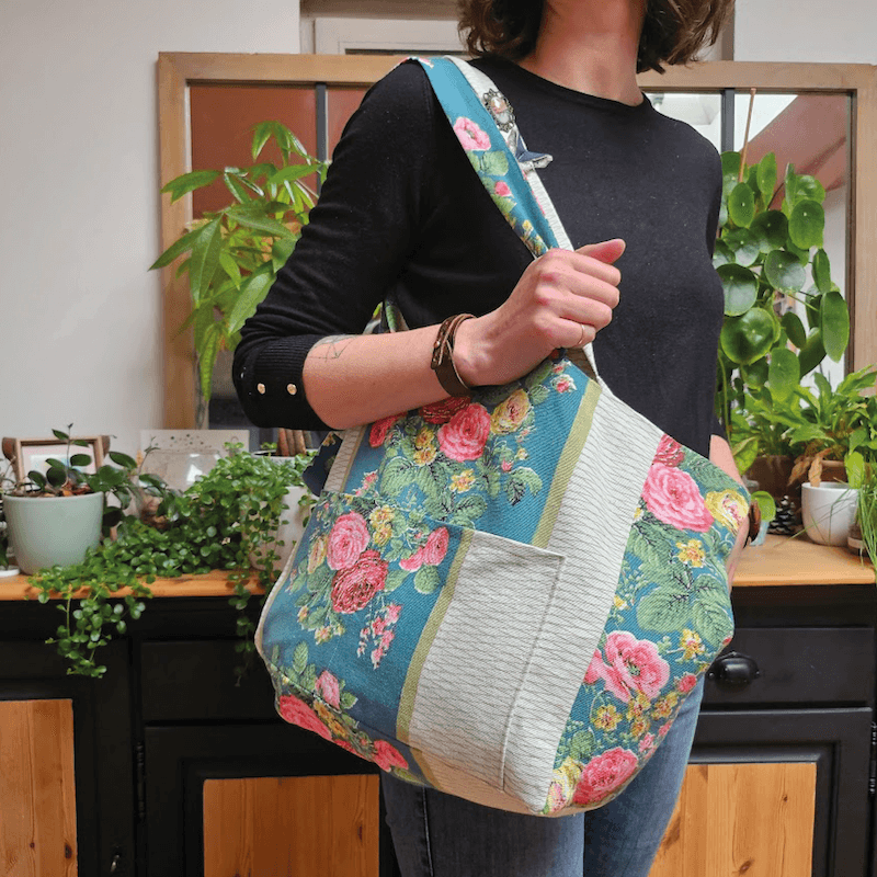 Cabas LOVER porté par une femme, patron de couture pdf à télécharger, floral, taille medium avec poches intérieures et extérieures.