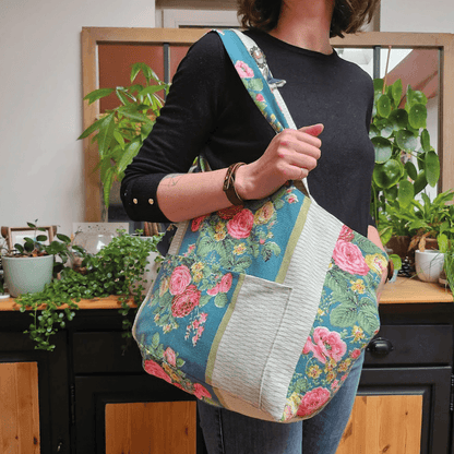 Cabas LOVER porté par une femme, patron de couture pdf à télécharger, floral, taille medium avec poches intérieures et extérieures.