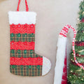 Calendrier de l'avent chaussette de Noël en tissu, patron de couture PDF à télécharger, suspendu près d'un sapin décoré.
