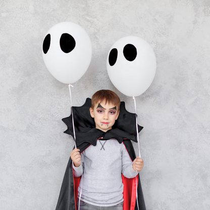 Enfant déguisé en vampire pour Halloween avec cape noire, tenant des ballons, cape de vampire pour Halloween patron de couture pdf à télécharger.