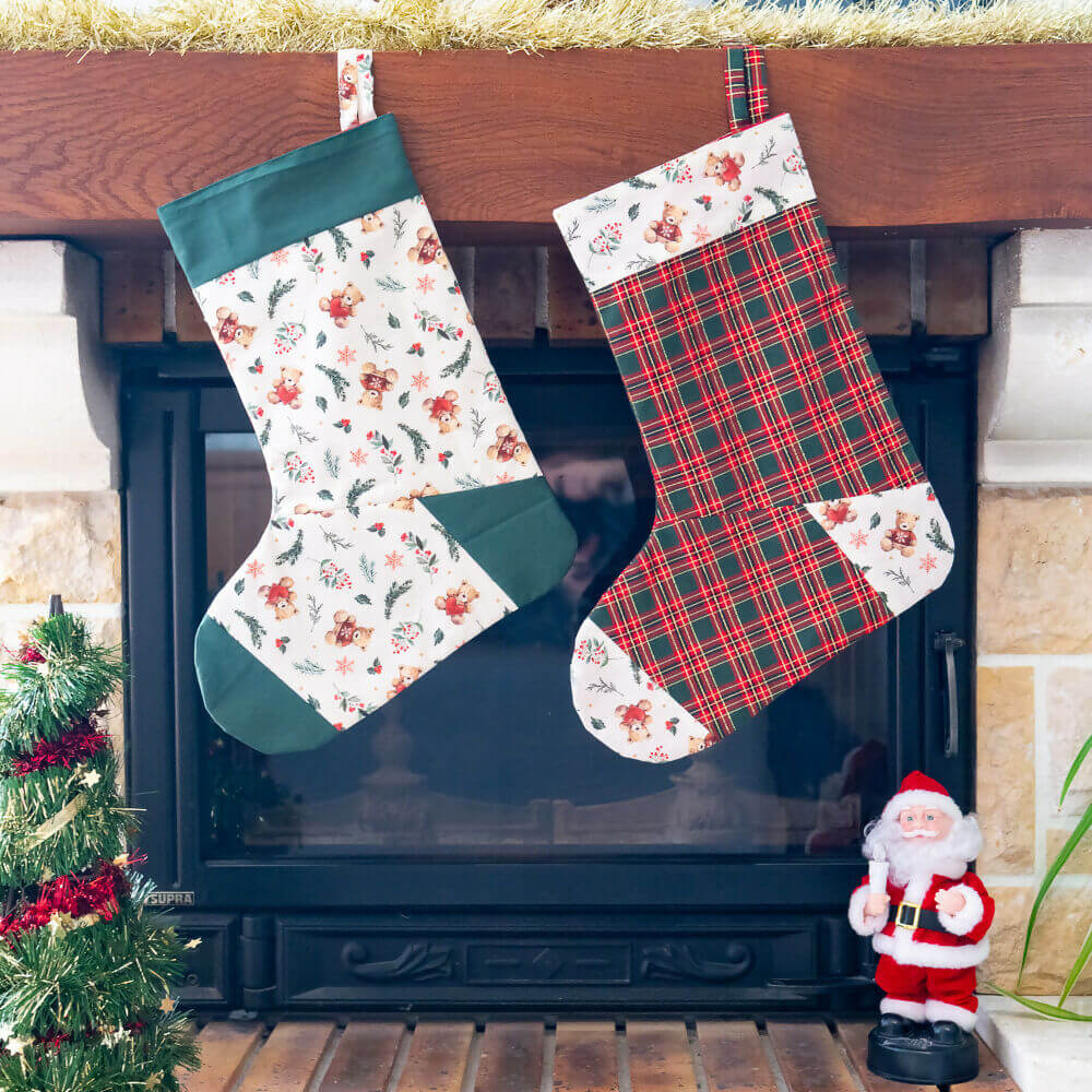 Chaussettes de Noël décoratives en tissu, un modèle fleuri et un modèle à carreaux, suspendues au-dessus d'une cheminée.