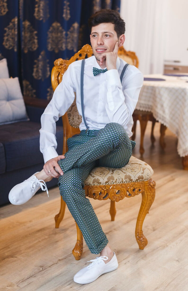 Homme élégant portant une chemise classique, assis sur une chaise en bois sculpté, ambiance chic et décontractée.