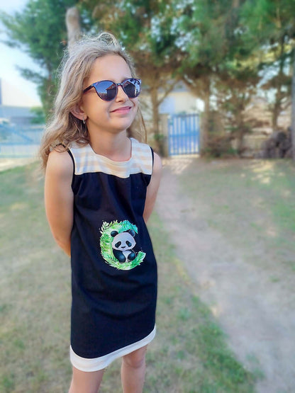Jeune fille portant une robe pandas dans un jardin verdoyant.