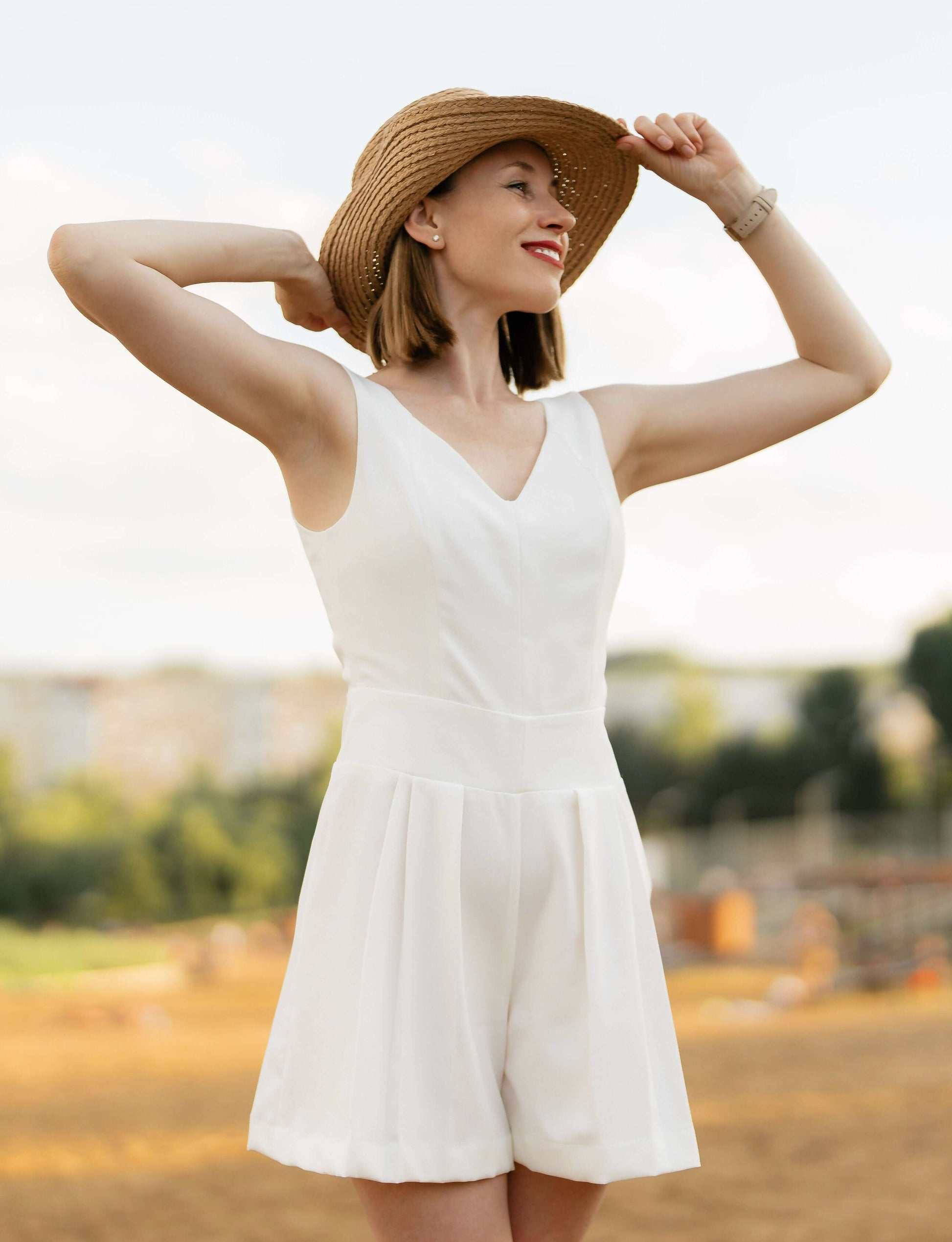 Femme en combinaison blanche estivale avec chapeau en plein air, style élégant et moderne, modèle patron de couture PDF à télécharger.