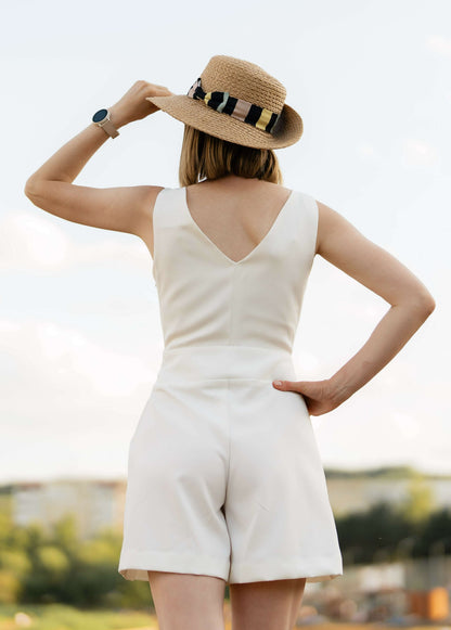 Femme en combinaison d'été blanche portant un chapeau, représentant le patron PDF "Combinaison - XS/XL - MAGNOLIA" de MUNA Patterns.