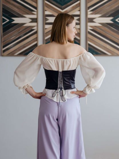 Femme portant un Corset - XS/L - CARMEN, patron de couture pdf à télécharger, vue de dos avec un corset noir et une blouse blanche.