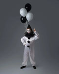 Enfant déguisé en clown ANALYA avec ballons noirs et blancs, prêt à s'amuser pour une fête.