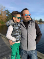 Père et fils portant Duo KEZIA - Doudoune sans manches mixte au bord d'un lac, idéale pour la mi-saison, patron de couture pdf à télécharger.